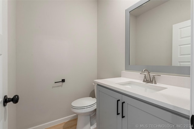 bathroom featuring hardwood / wood-style flooring, vanity, and toilet