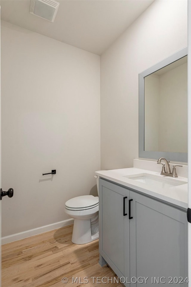 bathroom featuring vanity, hardwood / wood-style flooring, and toilet