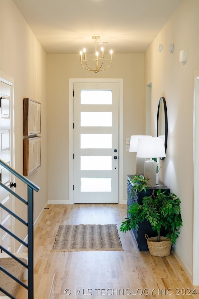 foyer featuring a notable chandelier, light hardwood / wood-style floors, and a healthy amount of sunlight