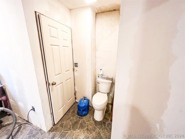 bathroom with tile flooring and toilet