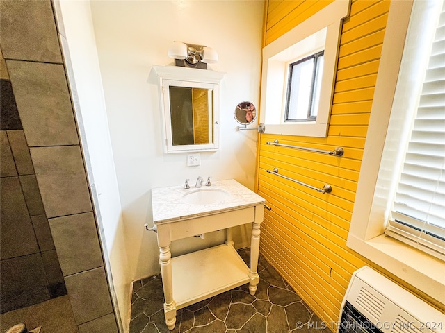 bathroom with wood walls, oversized vanity, and tile floors