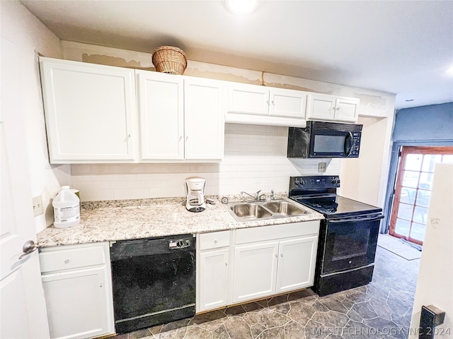 kitchen featuring sink, dark tile flooring, black appliances, tasteful backsplash, and white cabinetry