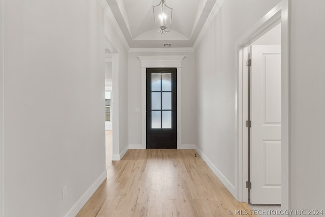 entrance foyer with visible vents, baseboards, vaulted ceiling, light wood-type flooring, and crown molding