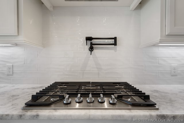 room details with stainless steel gas stovetop and tasteful backsplash