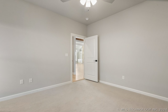 carpeted spare room featuring ceiling fan