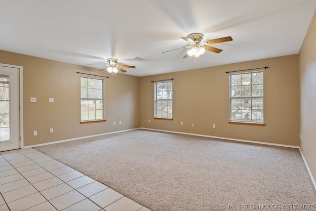 empty room with ceiling fan and light tile flooring