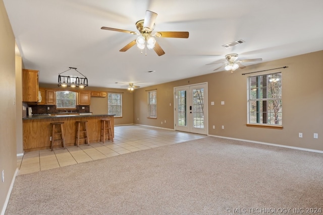 kitchen with french doors, backsplash, ceiling fan, and light colored carpet