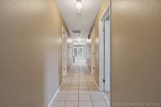 hall featuring light tile flooring