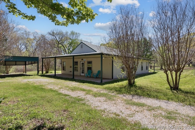 view of side of home featuring french doors, a carport, and a yard