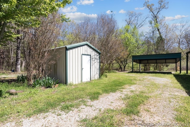 view of outdoor structure featuring a carport and a lawn