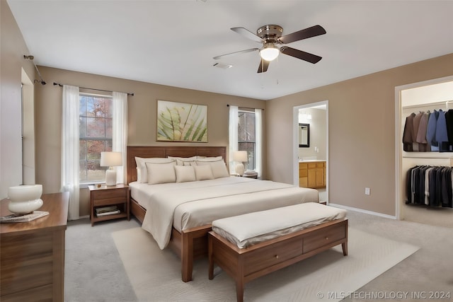 carpeted bedroom featuring ceiling fan, a closet, and ensuite bath