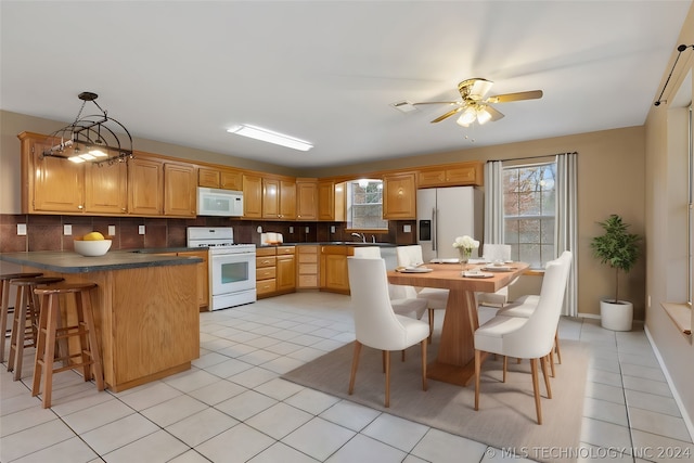 kitchen with tasteful backsplash, white appliances, and light tile floors