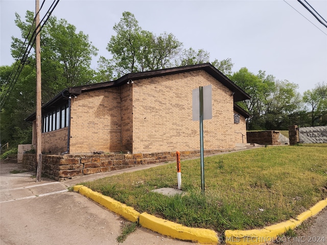 view of side of property with a lawn