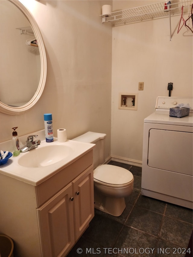 bathroom with toilet, tile flooring, oversized vanity, and washer / dryer