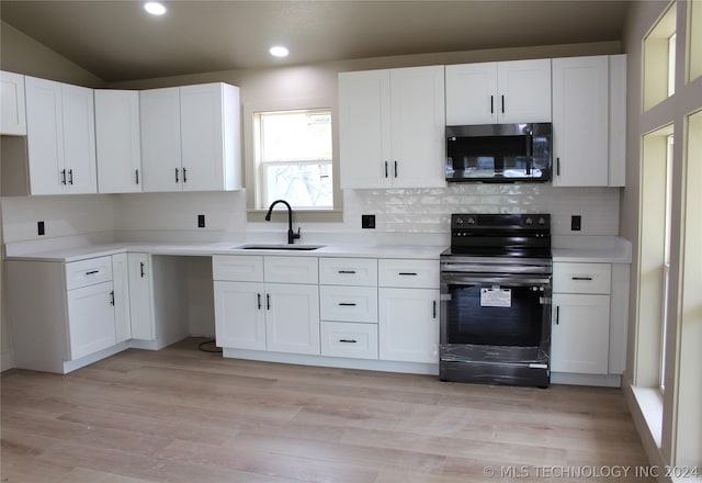 kitchen featuring sink, white cabinets, tasteful backsplash, and black appliances