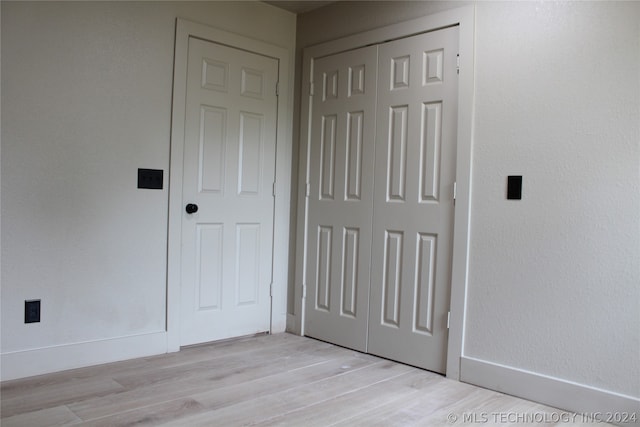 unfurnished bedroom with a closet and light wood-type flooring