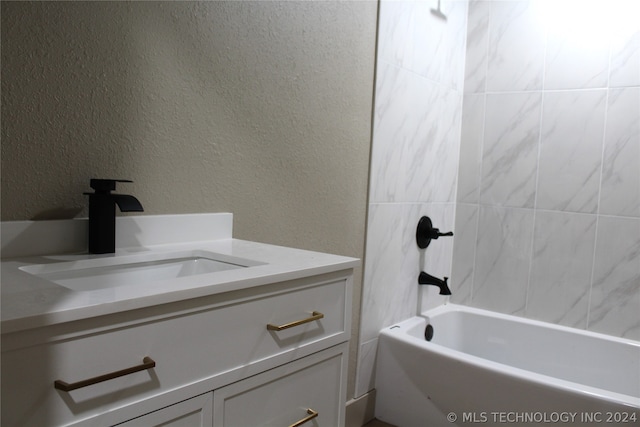 bathroom featuring tiled shower / bath combo and vanity