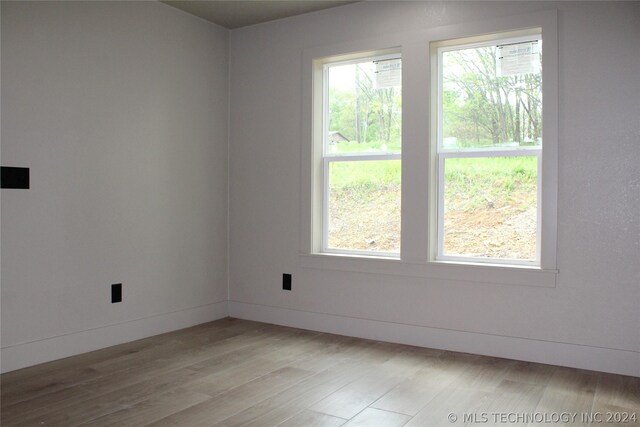 empty room with hardwood / wood-style floors and plenty of natural light