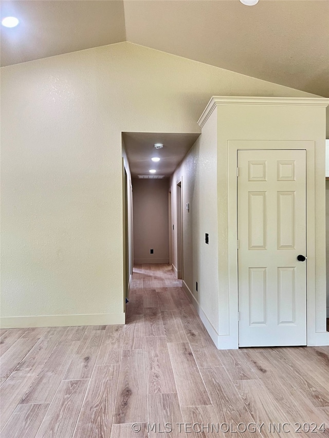 hallway featuring light hardwood / wood-style flooring and lofted ceiling