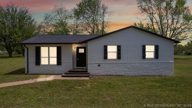 ranch-style home featuring a lawn