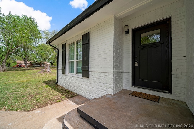 doorway to property featuring a yard