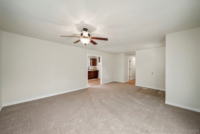 spare room with ceiling fan and light carpet