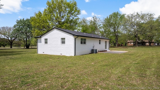 rear view of house featuring central air condition unit, a lawn, and a patio area