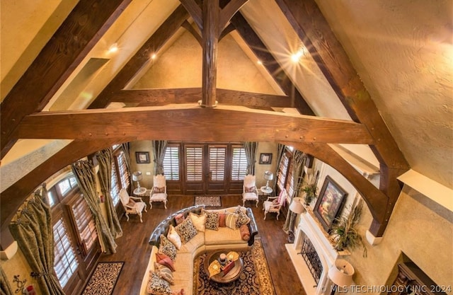 living room with dark hardwood / wood-style flooring, beamed ceiling, and high vaulted ceiling