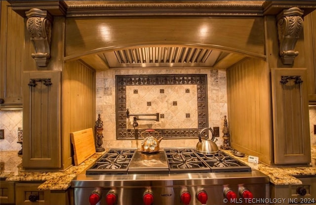 interior space featuring custom exhaust hood, stove, light stone counters, and tasteful backsplash