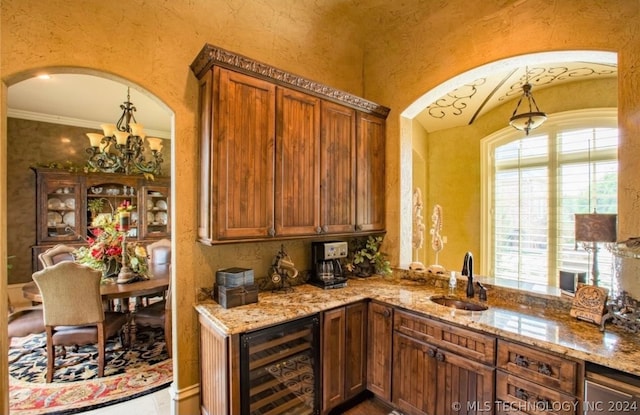 kitchen with ornamental molding, wine cooler, sink, and light stone counters