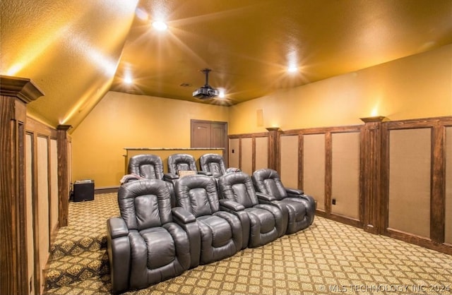 home theater room featuring light colored carpet and vaulted ceiling