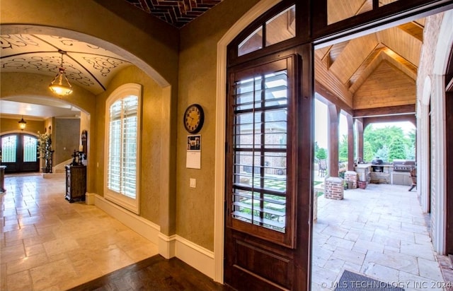 entryway with french doors, lofted ceiling, and light tile floors