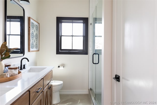 bathroom featuring an enclosed shower, vanity, tile patterned flooring, and a healthy amount of sunlight