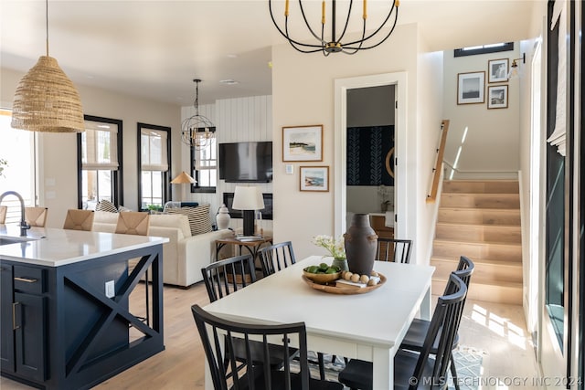 dining space featuring a chandelier, light hardwood / wood-style floors, and sink