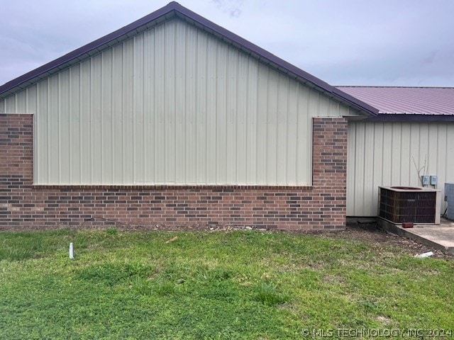 view of home's exterior featuring central AC unit and a lawn