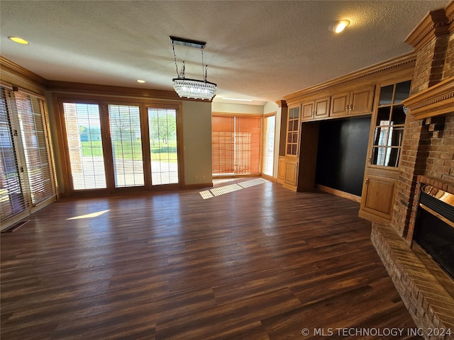 unfurnished living room featuring dark hardwood / wood-style flooring, a fireplace, an inviting chandelier, and a textured ceiling