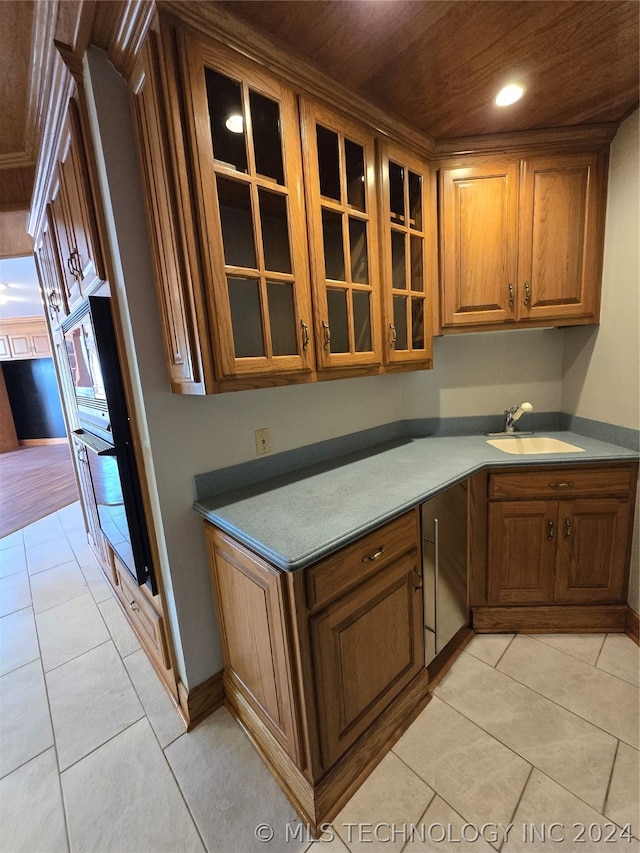 kitchen featuring sink, light tile flooring, and wood ceiling