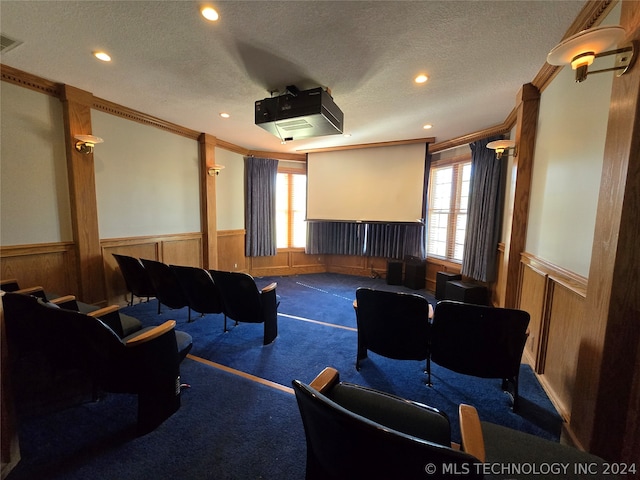 carpeted cinema with ornamental molding, a wealth of natural light, and a textured ceiling