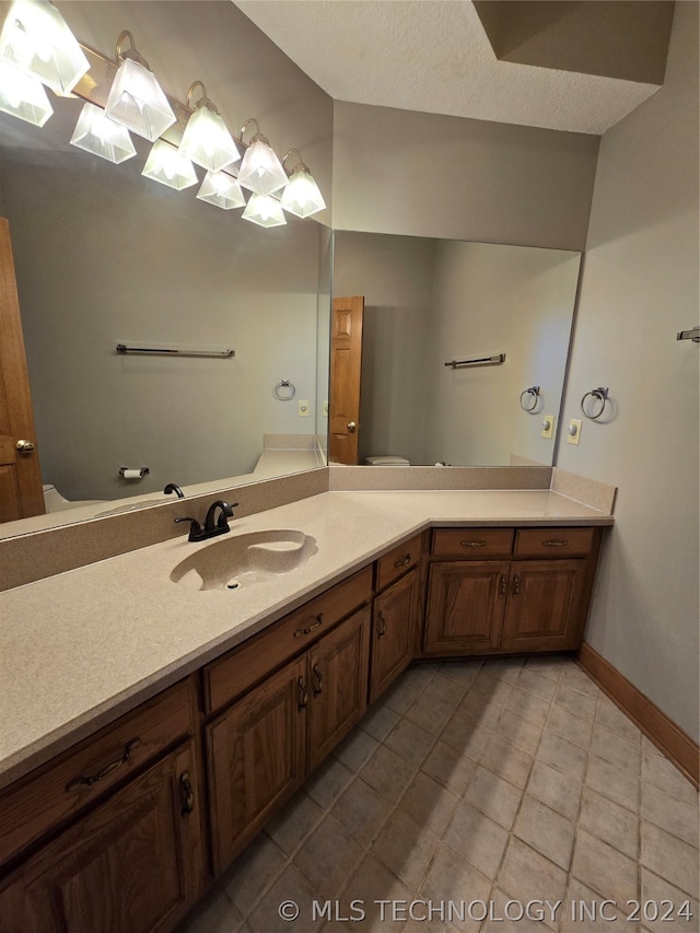 bathroom with vanity, tile floors, and a textured ceiling