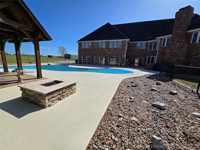 view of swimming pool featuring a patio and an outdoor fire pit