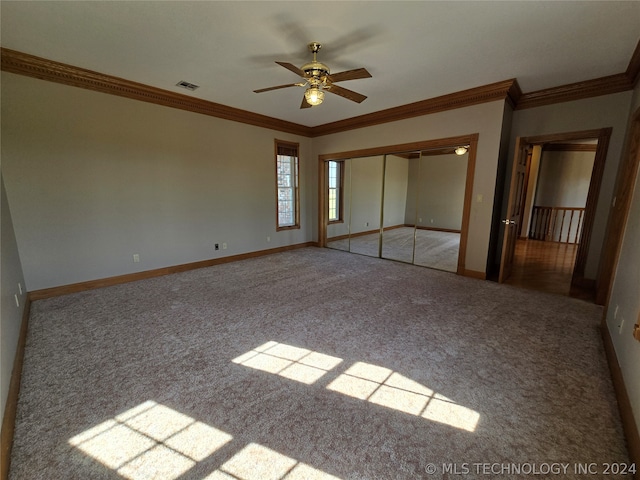 unfurnished bedroom featuring a closet, ceiling fan, light carpet, and crown molding