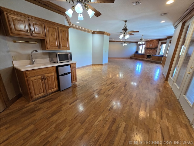 kitchen featuring ceiling fan, crown molding, dishwasher, hardwood / wood-style flooring, and sink