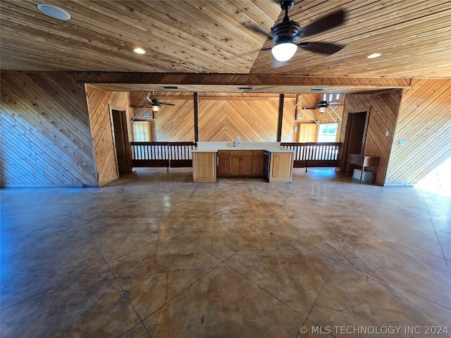 unfurnished living room with ceiling fan, dark tile floors, and wood ceiling