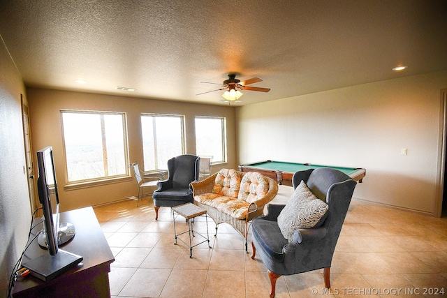 tiled living room featuring ceiling fan, billiards, and a textured ceiling