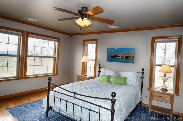 bedroom with crown molding, light hardwood / wood-style flooring, and ceiling fan