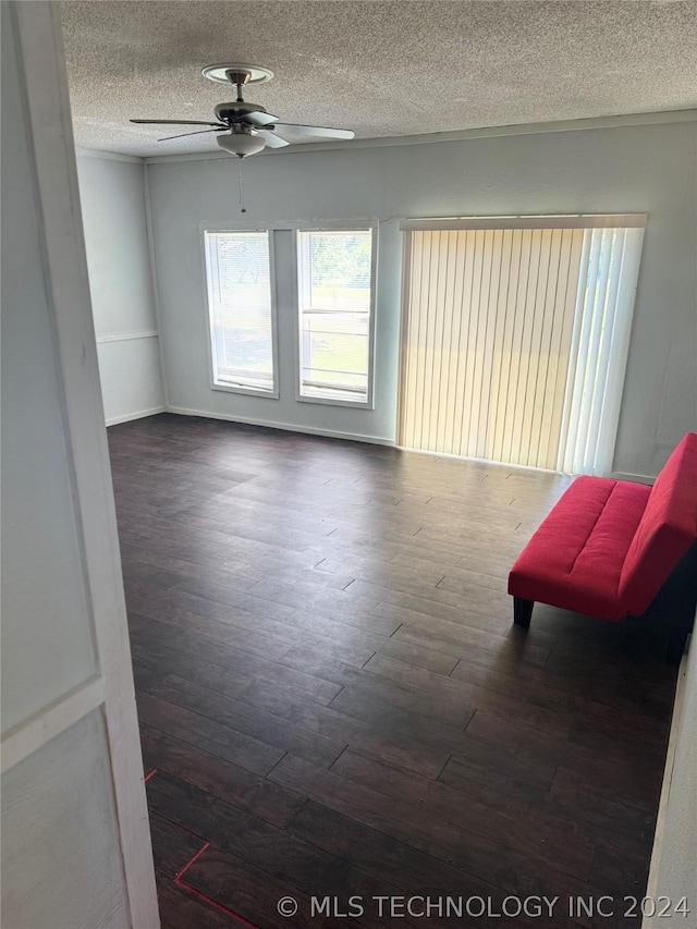 interior space featuring ceiling fan, a textured ceiling, and dark hardwood / wood-style floors