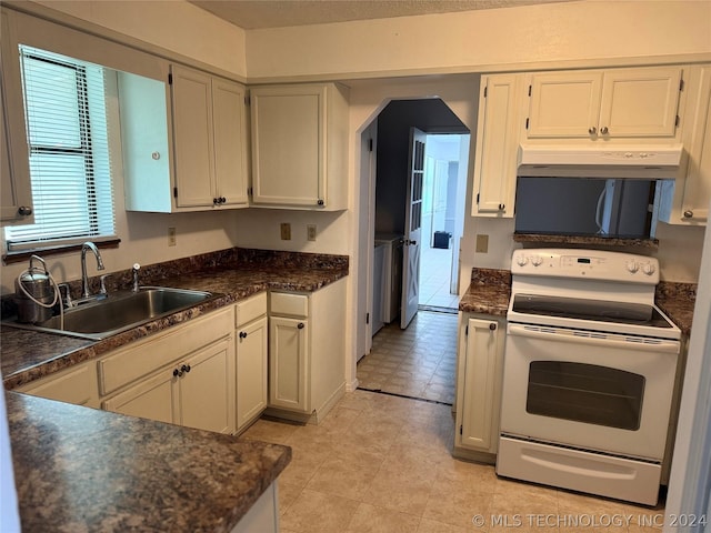 kitchen featuring sink, white cabinets, and electric range