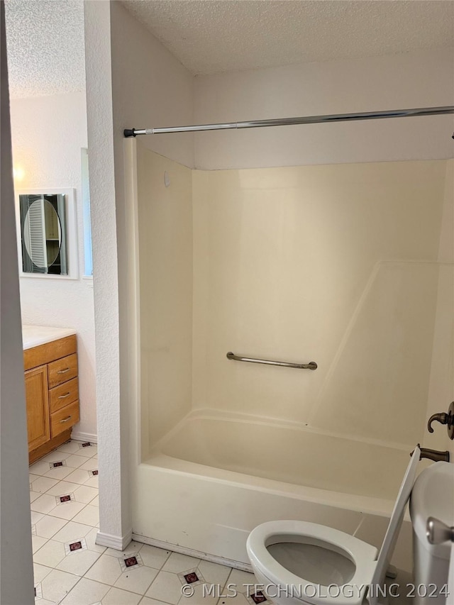 full bathroom featuring toilet, a textured ceiling, tile patterned flooring, washtub / shower combination, and vanity