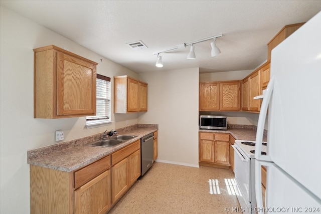 kitchen featuring appliances with stainless steel finishes, sink, and track lighting