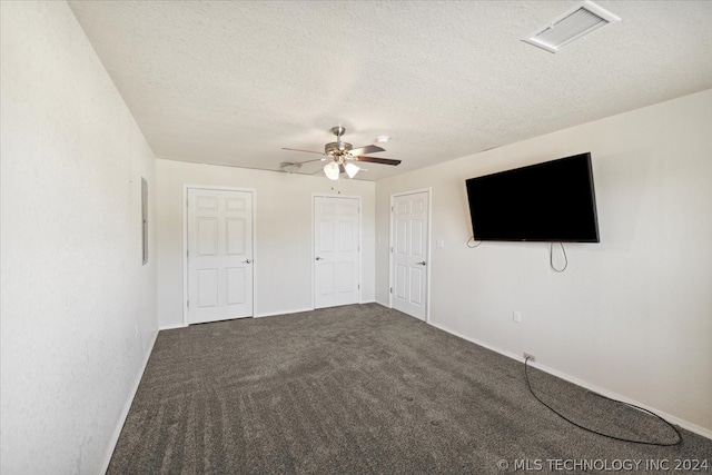 empty room featuring a textured ceiling, ceiling fan, and carpet flooring